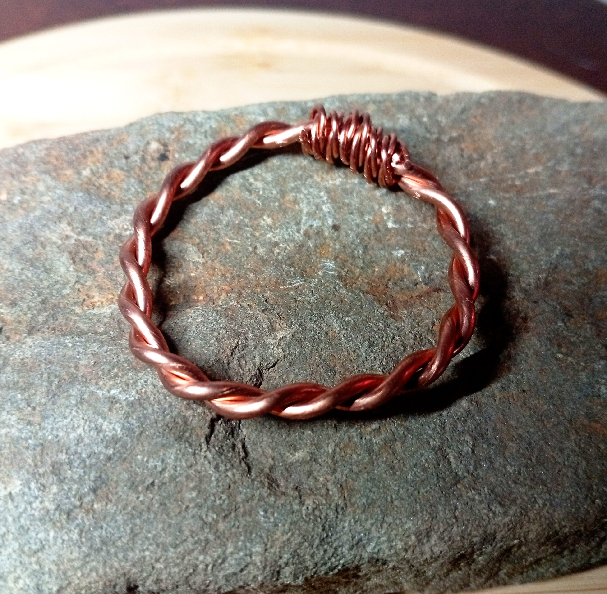 Handmade copper tensor ring on natural stone surface